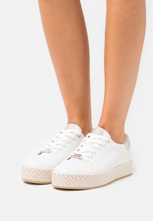 Weiße Schnürsneaker mit einer geflochtenen Jutefläche. Mit einem metallischen Akzent an der Ferse und einem geprägten Logo. Glatte Materialoberfläche.