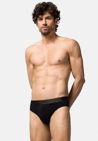 Czarne slipy męskie z zielonym paskiem w talii z logo "Lancerto". Wykonane z miękkiego materiału, mają dopasowany, niski krój.