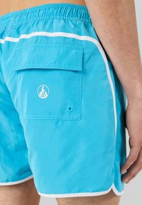 Pantaloni da nuoto blu con una finitura leggera e lucente, dotati di una striscia bianca decorativa, tasca posteriore e un logo circolare sulla tasca.