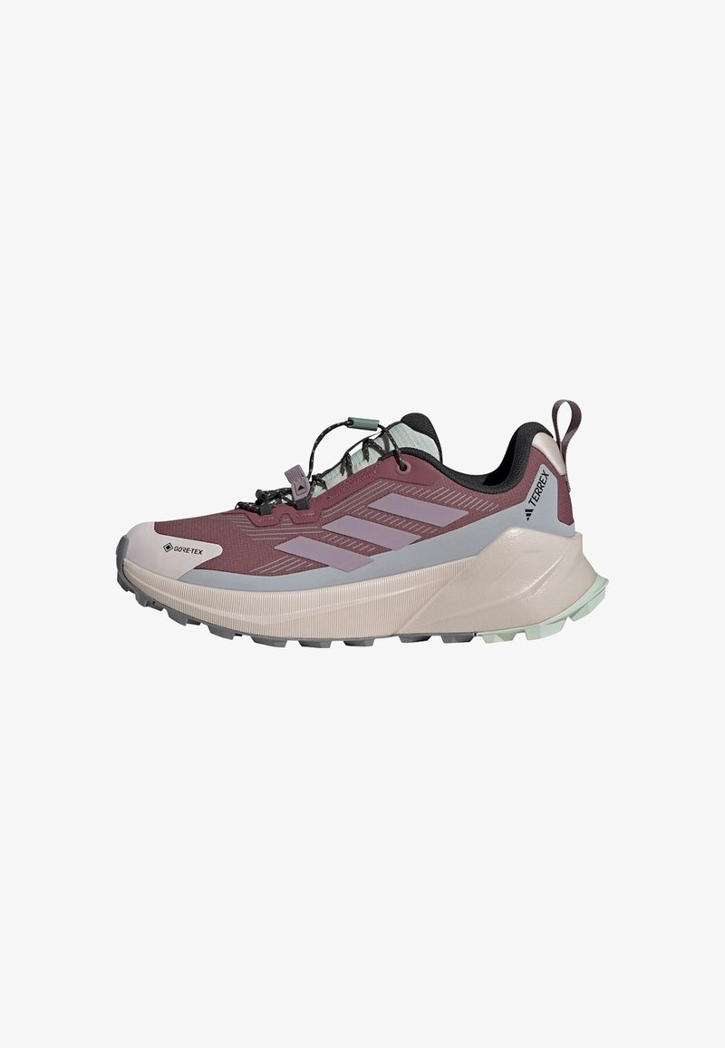 Lichtgewicht trailrunning schoen in bordeauxrood en grijs met een gestructureerde afwerking. Bevat een Gore-Tex-label, rubberen zool en elastische veters.