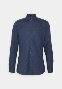 Granatowa koszula z długim rękawem w białe kropki, zapinana na guziki z przodu, z kołnierzykiem i zaokrąglonym dołem. Wykonana z gładkiej tkaniny.