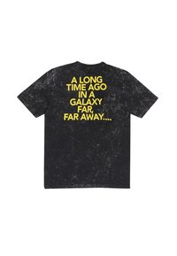 Černé tričko s vybledlou texturou. Na zadní straně je výrazný žlutý text: "PŘED DLOUHOU DOBOU V GALAXII DALKO, DALKO ODKUD..."