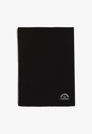 Fekete szövet sál sima textúrával. Az egyik sarokban ívelt logó címke található, amely a márkanevet és a címet mutatja.