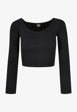 Mustan värinen lyhyt, pitkähihoinen paita, joka on valmistettu ribbimäisestä materiaalista. Ominaisuuksiin kuuluu leveä pyöreä kaula-aukko ja istuva muoto. Merkkilabeli näkyy kaula-aukon sisällä.