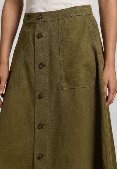 Falda verde oliva hecha de tela texturizada, con un cierre frontal de botones, dos bolsillos laterales y detalles de botones marrones.