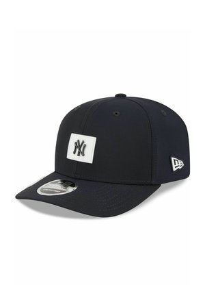 Black baseball cap with New York Yankees logo on front and New Era logo on side, featuring a curved brim and adjustable strap.