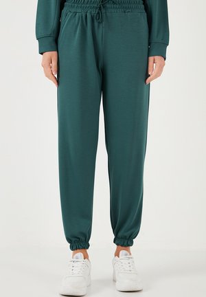 Pantaloni jogger color teal realizzati in tessuto morbido con vita e polsini elasticizzati. Presentano tasche laterali, vestibilità comoda e una superficie liscia.