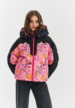 Kurtka puchowa z czarnym kapturem i rękawami, z jasnoróżowym korpusem ozdobionym wyraźnymi wzorami słońc, księżyców oraz różnorodnymi kolorowymi motywami.
