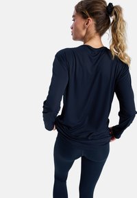 Lange mouwen sportshirt in marineblauw, met een gladde, rekbare stof en een relaxte pasvorm. Geïntegreerde duimgaten bij de manchetten voor extra comfort.