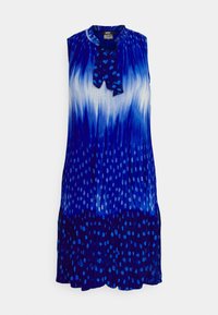 Robe bleue sans manches avec un dégradé blanc et un motif de points dispersés, avec un col à volants et un nœud noué au col.