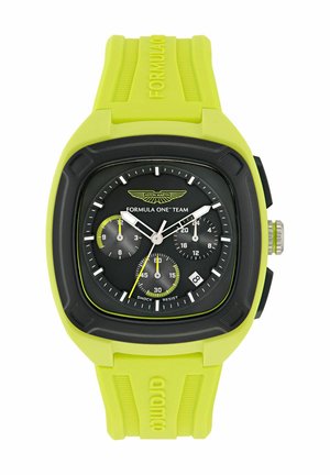 Kronografas su geltonu silikono dirželiu, juodu ciferblatu, sidabro akcentais ir keliais subciferblatais. Yra žymėjimas "SHOCK RESIST" ir logotipas.