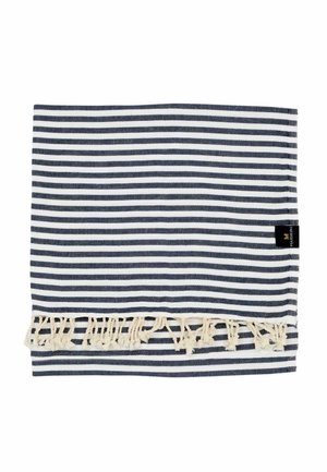 Zložená námornícka modrá a bielo pruhovaná látka s krémovými strapcami a malou čiernou značkovou etikietou na bielom pozadí.