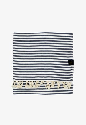 Tessuto piegato a righe blu navy e bianche con nappe di frangia color crema e una piccola etichetta del marchio nera su sfondo bianco.