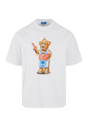 Hvid kortærmet t-shirt med en farverig tegneserie-bjørn, der holder en malerpensel og palet, udsmykket med livlige mønstre og teksturer.