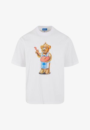 Fehér, rövid ujjú póló, rajta egy színes mesebeli medvével, aki festőecsettel és palettával látható, élénk mintákkal és textúrákkal részletezve.