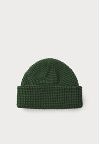 Beanie verde a maglia con texture a coste, dotato di risvolto e punta arrotondata. Realizzato in materiale morbido ed elastico.