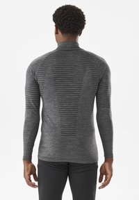 Szary, długi rękaw, z wysokim kołnierzem, z teksturalnym prążkowaniem i poziomymi paskami z tyłu, wykonany z gładkiego, elastycznego materiału.