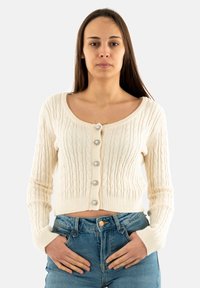 Cárdigan de punto trenzado color crema con un cuello redondo, mangas largas y cinco botones decorativos en el frente. Diseño corto.