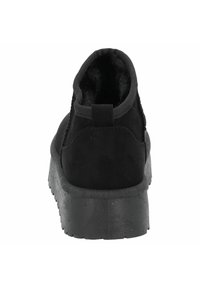 Botines negros con parte superior de suave ante, cuello acolchado y suela de goma texturizada, que cuentan con una lengüeta en la parte posterior para facilitar su puesta.