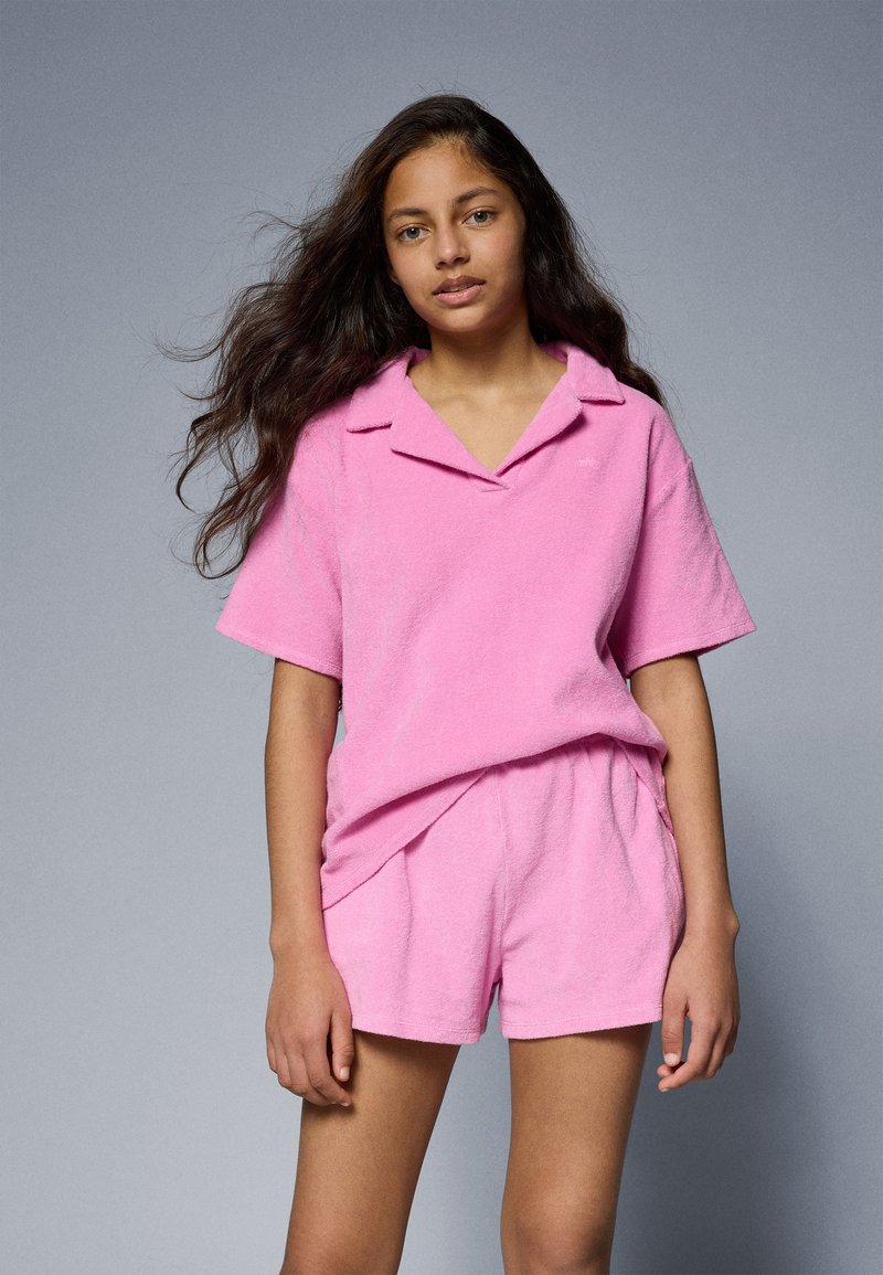 Rosa terryklut-kordinert sett med kortermet skjorte med krage og matchende shorts, med en myk tekstur og avslappet passform.