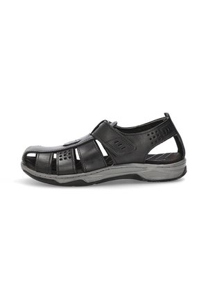 Sandalia de cuero negro con diseño abierto, que cuenta con orificios de ventilación y una correa de cierre de gancho y bucle. Suela texturizada, con un tacón ligeramente elevado.
