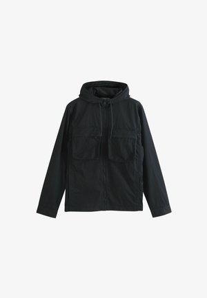 Musta kapuutsiga jakk, mis on valmistatud kergest kangast, sisaldab kahte esipaneeli Taskut, lukuga sulgemist ja reguleeritavat nööri kapuutsis.