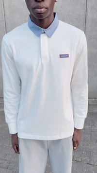 Long-sleeve white polo shirt with a light blue collar, featuring a small GANT logo patch in red and blue on the left chest.