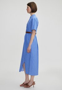 Abito midi a righe blu con colletto, maniche corte, cintura in vita e spacco laterale; tessuto testurizzato con una finitura liscia.