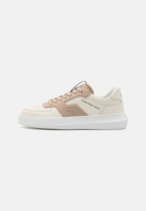 Beżowo-białe niskie trampki sznurowane, z grubą białą podeszwą i logo "Calvin Klein Jeans" po boku.