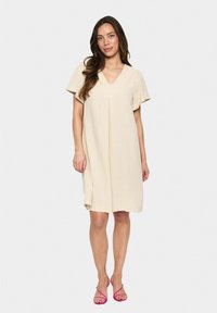 Beiges knielanges Kleid mit kurzen Schmetterlingsärmeln und V-Ausschnitt. Verfügt über eine subtile vordere Falte und einen leichten, strukturierten Stoff.