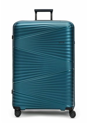 Valise rigide teal avec un design rainuré, poignée rétractable et quatre roues pivotantes à 360 degrés. Logo de la marque visible.