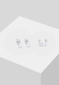 Pendientes de plata con una superficie redonda y lisa, y un aro grueso y pulido. El diseño presenta líneas limpias y un estilo minimalista.