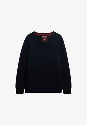 Marineblauwe gebreide trui met een v-hals, geribbelde boorden en zoom. Heeft een rode accent op de halslijn en een merketiket aan de binnenkant.