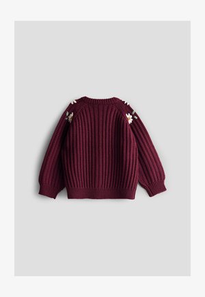 Burgundi színű kötött pulóver, bordás textúrával, hosszú ujjal és virágos hímzés díszítéssel a vállvarratokon.