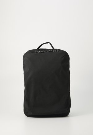 Sac à dos noir en tissu avec une texture lisse, de forme rectangulaire et une poignée supérieure. Présente un design simple, sans motifs ou accents marquants.