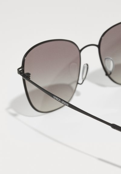 Black metal sunglasses with gradient lenses, featuring a geometric frame design, logo on the arm, and clear nose pads for comfort.