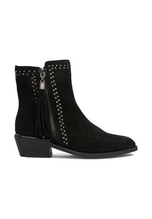 Botte de cheville en daim noir avec une fermeture éclair sur le côté, des accents cloutés et un détail en pompon. Talon bas, bout rond et texture lisse.