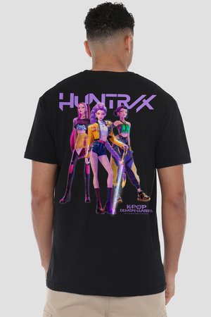 Mann trägt schwarzes T-Shirt mit drei animierten K-Pop-Stil weiblichen Charakteren und den Texten "HUNTRX" und "K-POP DEMON HUNTERS" auf dem Rücken.