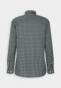 Camisa de botones con un patrón de cuadros azul y blanco, mangas largas y cuello. La tela parece texturizada con costuras visibles.