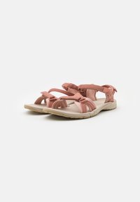 Två rosa sandaler med justerbara tygremmar, en texturerad gummisul, och en vadderad fotbädd. Lätta och designade för komfort och stöd.