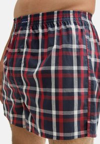 Karierte Boxershorts in Marineblau, Rot und Weiß mit elastischem Taillenbund, einem Knopfverschluss und weichem Baumwollmaterial.