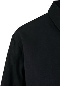 Black shirt featuring a collar, shown from the shoulder area. The fabric appears textured, with clean stitching visible on the seam.