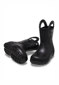 Une paire de bottes en caoutchouc noires imperméables avec un bout et une semelle texturés, logo sur le côté et poignées pour un enfilage facile, présentées sur un fond blanc.
