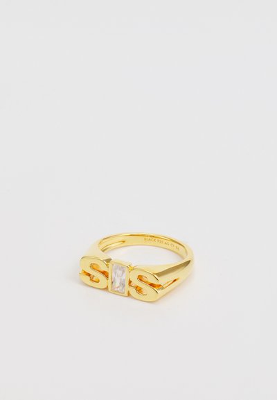 Goldfarbener Ring mit den Buchstaben "SIS", einem zentralen rechteckigen klaren Stein, glatter Oberfläche und breitem Band. Mit "BLACK 925 AG" gekennzeichnet.