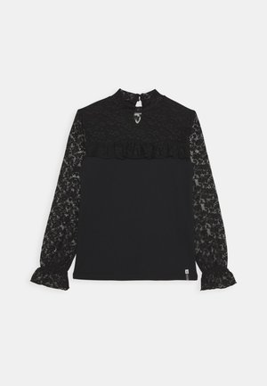 Blusa negra de manga larga con mangas de encaje, parte superior del pecho de encaje, detalle de volantes debajo del cuello y cierre de botones en la parte posterior del cuello.