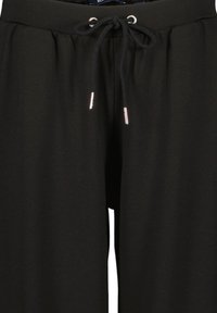 Zwarte broek met een tailleband met trekkoord, voorzien van zilveren metalen accenten op de uiteinden van het trekkoord. Gemaakt van glad, lichtgewicht stof.