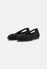 Sorte semskede ballerinasko med rund tå, elastiske utskjæringer på sidene og flat gummisåle. Glatt tekstur og minimalistisk design.