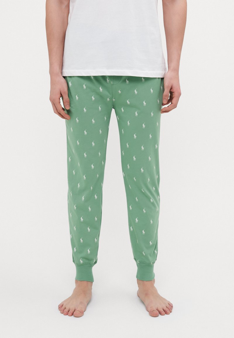 Pantalons de pyjama verts en coton doux avec de petits motifs de logo blancs, dotés de poignets élastiques et d'une taille à cordon.