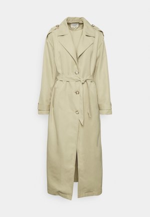 Trench-coat beige long avec trois boutons, une ceinture à nouer à la taille, de larges revers, des épaulettes et des sangles aux poignets.