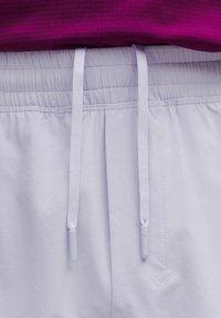 Ljust lavendelfärgade shorts med ett elastiskt midjeband och vita dragband, med en slät tygstruktur och subtila sömdetaljer.